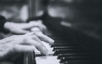 mains jouant sur un clavier de piano