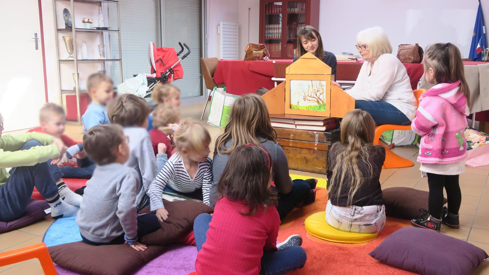 photo d'enfants assis écoutant des conteurs